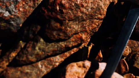 Sword rests on rocky surface in sunlight during outdoor setting Stock Footage 340228821