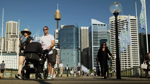 Sydney couple push a pram over Pyrmont Bridge in Darling Harbour 6K Video stock 301024546