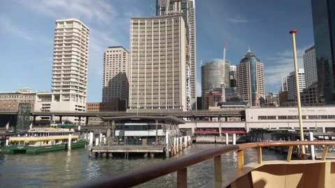 Sydney ferry docking at Circular Quay with the city’s towering buildings Vidéo 248961761