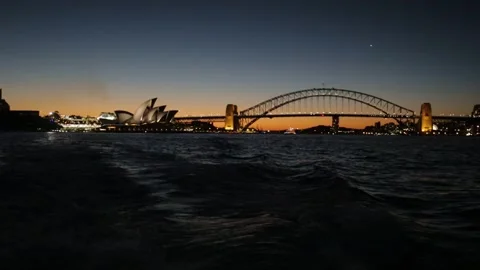 Sydney Harbour Bridge and Opera House Illuminated at Dusk Across the Water Stock Footage 345719644