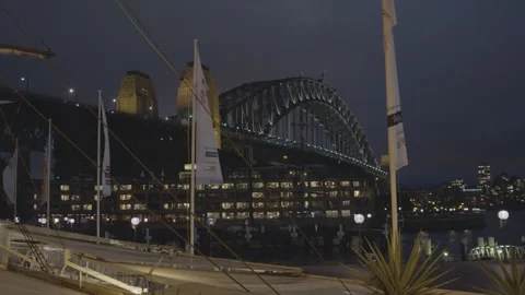 Sydney Harbour Bridge at Night with Waterfront and Flags in Evening Cityscape Stock Footage 345716620