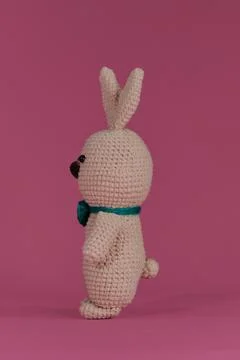 Symbol of Catholic Easter. Grey cute Easter bunny with green bow tie crochete Stock Photos