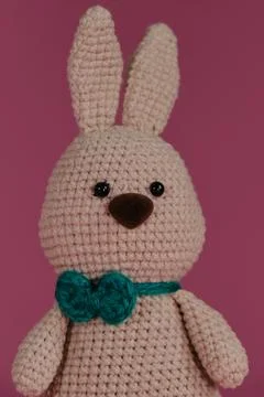 Symbol of Catholic Easter. Grey cute Easter bunny with green bow tie crochete Foto stock