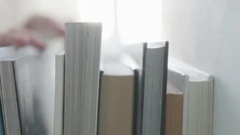 Symbol of discovery A close up of a hand selecting a hardcover book. Stock Footage 301241915