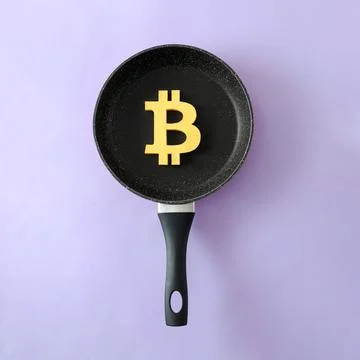 The symbol of the modern digital cryptocurrency Bitcoin in a frying pan as .. 스톡 사진