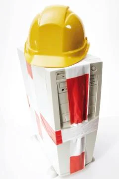 Symbol for pc repairs: computer tower, hard hat and caution tape Stock Photos