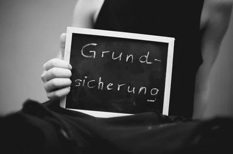 Symbolic image Child basic security child poverty child in torn clothes holds Stock Photos