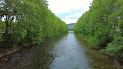 Symmetric view of Limmat river with lush green trees in Zurich Stock Footage 334631693