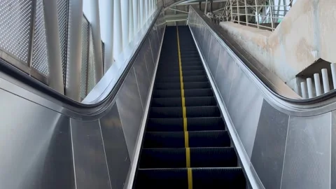 Symmetric wide static shot of an empty moving escalator going up at a moder.. Stock Footage 337583589