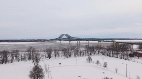 Symmetrical bridge structure over frozen river aerial Stock Footage 329395379