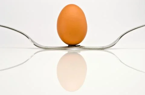 Symmetrical composition of two forks and an egg. Stock Photos