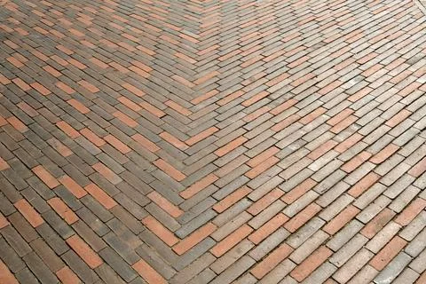 Symmetrical herringbone pattern of red and gray bricks creates dynamic geom.. Stock Photos