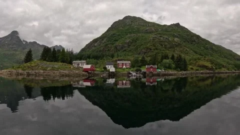 Symmetrical mirror reflection of traditional Norwegian rorbu cabins in fjord Stock Footage 344753157
