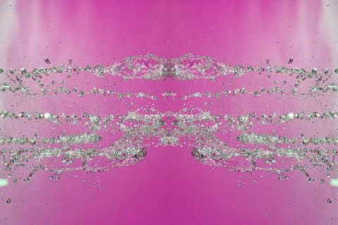 Symmetrical pattern of stopped water droplets with transparent streams on a p Stock Photos