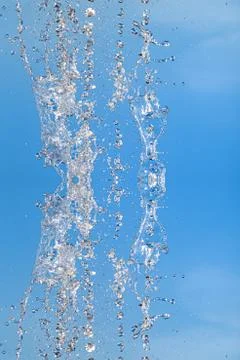 Symmetrical pattern of stopped water droplets with transparent streams on a b Stock Photos