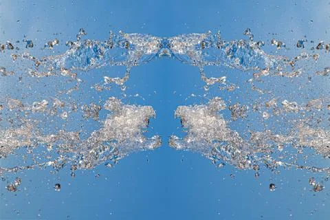 Symmetrical pattern of stopped water droplets with transparent streams on a b Stock Photos