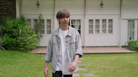 A symmetrical shot of a man in a jean jacket walking gracefully in a Video stock 249592474