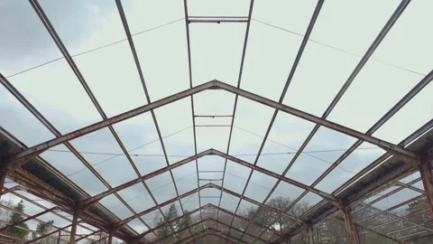 Symmetrical steel truss pattern inside deserted hangar with exposed skeleton and Stock Footage 336557707