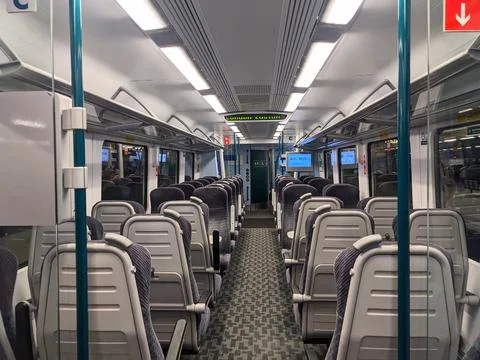 Symmetrical view down the empty aisle of a modern commuter train carriage bound Stock Photos