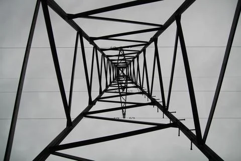 Symmetrical view inside high voltage electricity pylon Foto stock