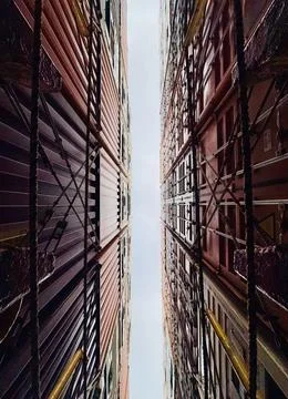 Symmetrical View Looking Up Between Shipping Containers on Cargo Ship with Drama Stock Photos