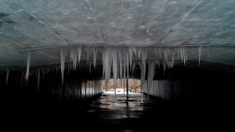 Symmetrical View of Massive Icicles Hanging Inside Concrete Culvert Underpass Stock Photos
