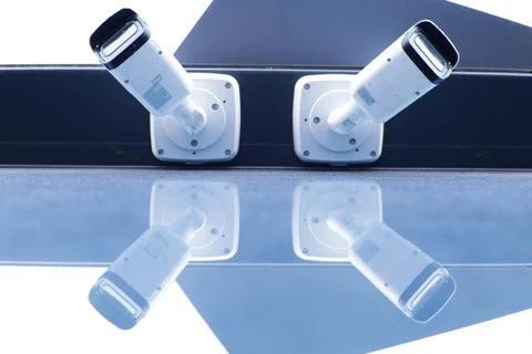 Symmetrical view of two modern security cameras mounted Stock Photos