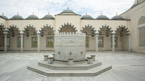 Symmetrical view of white marble ablution fountain in mosque courtyard with.. Foto stock