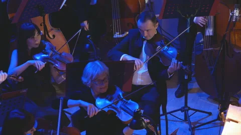 A symphony orchestra performs on stage with performers playing violins, cello Video stock 149981127