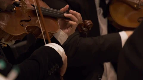 Symphony orchestra on stage, hands playing violin. Shallow depth of field. Stock Footage 121832491