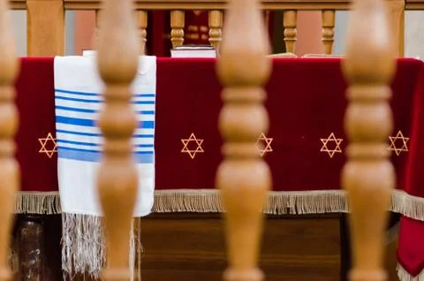 A synagogue table and a tallith through a wooden rail Foto stock