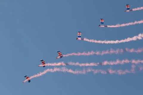 Synchronized Skydivers Creating Red Smoke Trails Fotos de archivo