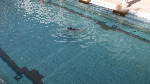 Synchronized swimmer performs graceful upside down pose in calm clear pool elega Stock Footage 310857453