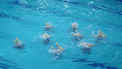 A synchronized swimming team performing synchronized kicking movements in a pool Stock Footage 310305920