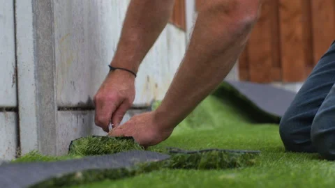 Synthetic artificial grass lawn installation cutting to fit border Stock Footage 305870078