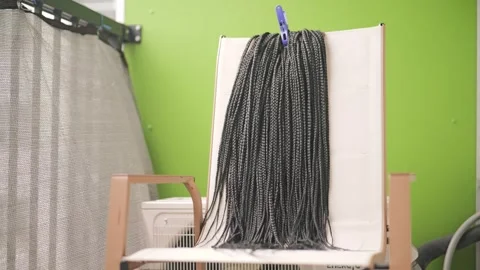 Synthetic box braid extensions hanging to dry on a balcony chair Stock Footage 339720636