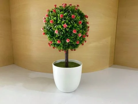 Synthetic or artificial small tree with flower in a white pot Foto stock