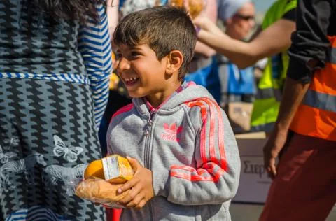 Syrian boy receive oranges from Charitable Organizations in a refugee camp Stock Photos