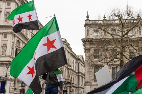 Syrian opposition flags waved during street protest demonstration Stock Photos