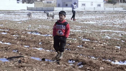 Syrian refugee boy walks on mud at a refugee camp in Beqaa, Lebanon Stock Footage 119470283