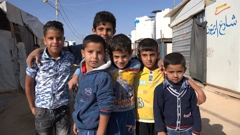 Syrian refugee kids pose for the camera inside the Zaatari camp in Jordan Vídeos de archivo 71529059