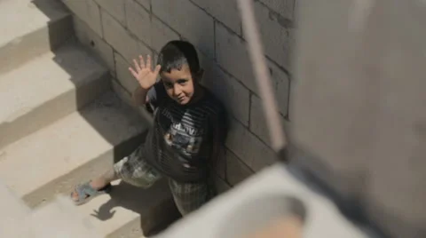 Syrian war refugee boy stands and waves on a staircase Stock Footage 64361822