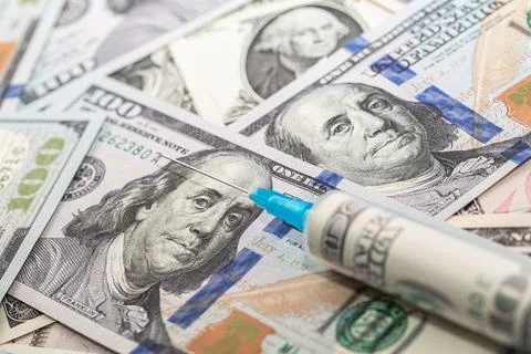 Syringe with 100 dollar banknote inside on dollar banknotes Stock Photos