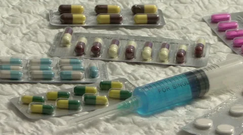 Syringe and blisters closeup Stock Footage