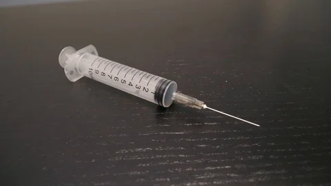 Syringe and Needle on a Table With Camera Turning Around Stock Footage 88405450