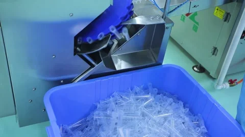 Syringe barrels fall from the conveyor into the container Stock Footage 163088176