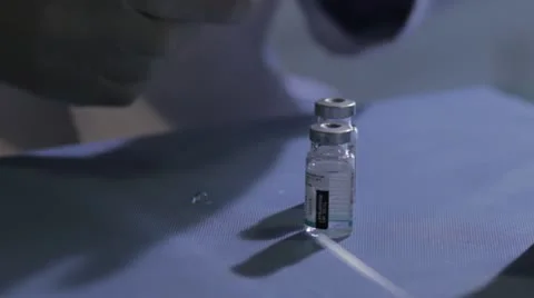 Syringe drawing clear fluid from container Stock Footage 20446448