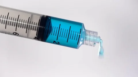 Syringe dropping blue liquid substance Stock Footage 84239468