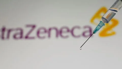 Syringe dropping vaccine in front of AstraZeneca logo Video stock 147413587