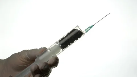 The syringe filled with coffee beans in the hands of the nurse Stock Footage 85672610